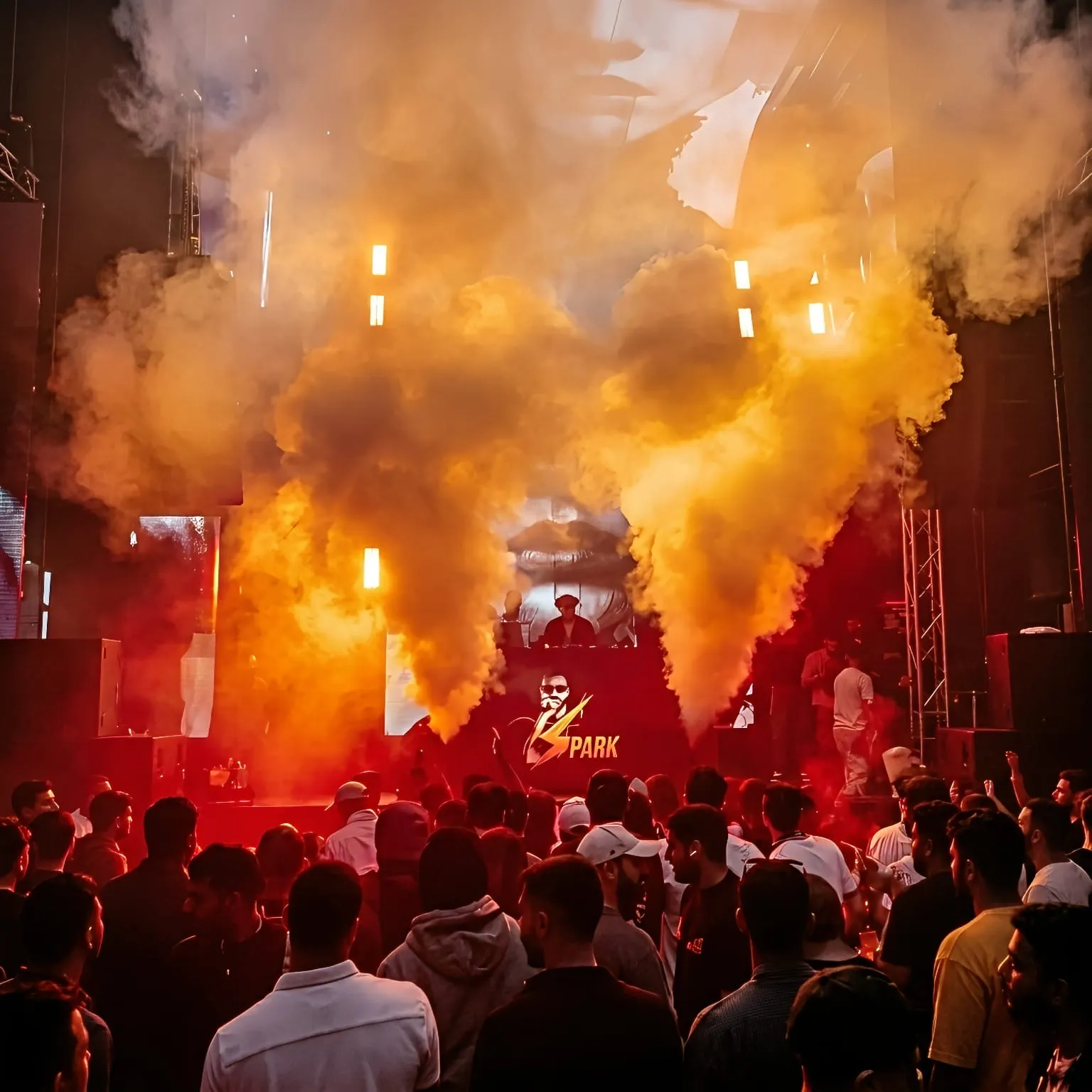 Orange haze clouds behind the DJ booth with the crowd watching from the floor